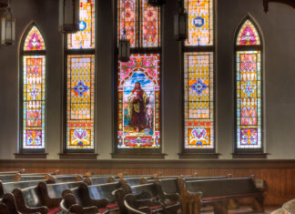 In times of hostility, be an instrument of God’s peace | Dr. Craig McMahan Interior of Mercer University's Newton Chapel with wooden pews and large stained glass windows featuring Jesus.