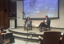 Speaker series looks at mental health care in sports Three women participate in a discussion on stage in an auditorium, with a Thank You slide projected behind them.