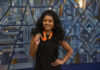 Mercer program helps freshmen grow as leaders on campus Georgia Taylor smiles while holding a medal on an orange ribbon in front of a geometric background.