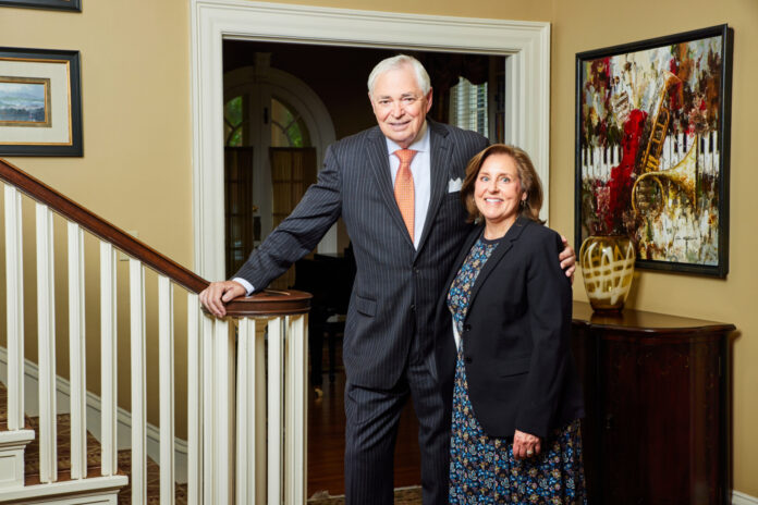 2025PresUnderwoodMattOdom009 President William D. Underwood and wife Lesli Underwood stand together beside a staircase in a well-decorated home interior.