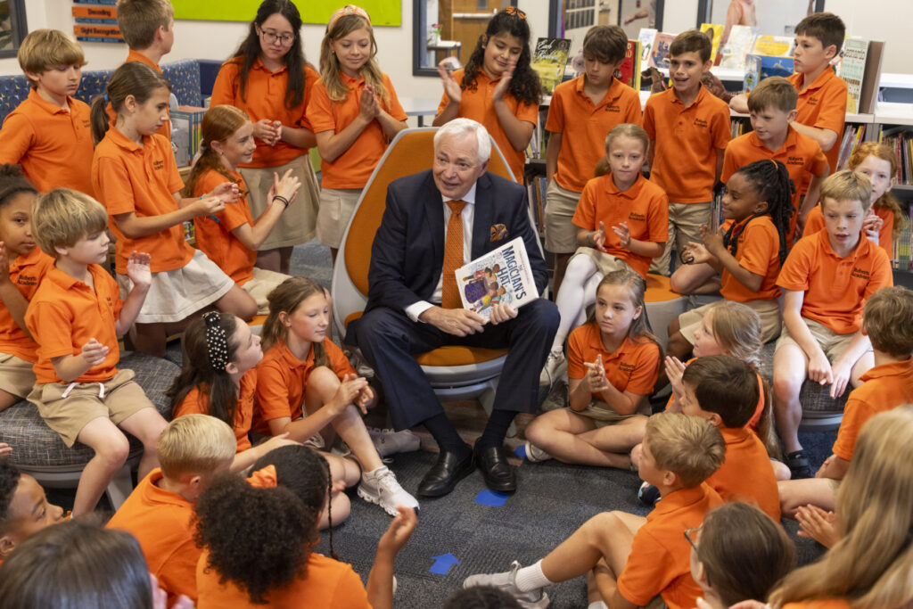 Mercer President William D. Underwood reads a book to a group of children at Roberts Academy.