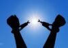 Release is a gift you can give yourself | Dr. Craig McMahan Silhouette of hands breaking free from handcuffs against a bright sun in a clear blue sky.