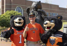 Mercer to welcome alumni and friends Nov. 14-15 for Homecoming 2025 A person in a Mercer University shirt poses with two bear mascots in front of a bear statue on campus.