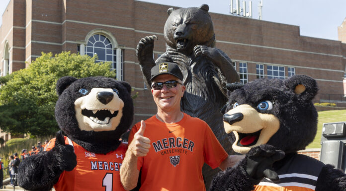 Mercer to welcome alumni and friends Nov. 14-15 for Homecoming 2025 A person in a Mercer University shirt poses with two bear mascots in front of a bear statue on campus.