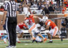 3 things to know about Mercer vs. Chattanooga football game day: Nov. 15, 2025 A football player in an orange jersey runs with the ball as two teammates block and a referee stands nearby.