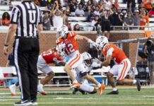 3 things to know about Mercer vs. Chattanooga football game day: Nov. 15, 2025 A football player in an orange jersey runs with the ball as two teammates block and a referee stands nearby.