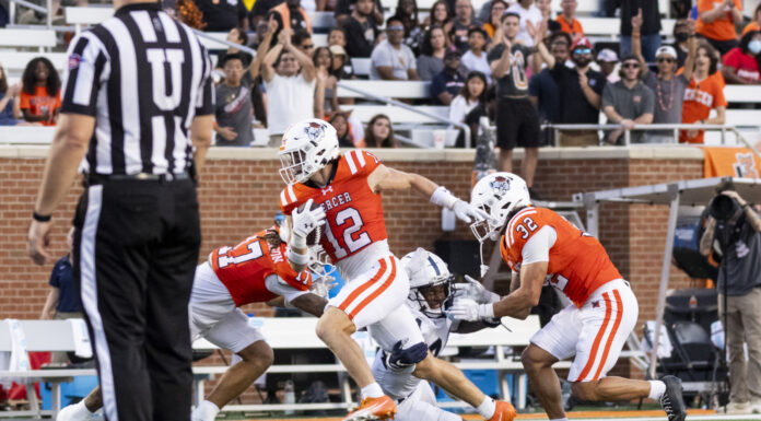 3 things to know about Mercer vs. Chattanooga football game day: Nov. 15, 2025 A football player in an orange jersey runs with the ball as two teammates block and a referee stands nearby.