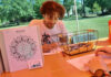 Princeton Review names Mercer to 2026 Mental Health Services Honor Roll A man sits at an outdoor table coloring a mandala design with colored pencils beside a basket of art supplies.