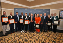10th annual Alumni Awards Reception recognizes outstanding Mercerians A group of people stand indoors holding awards and framed certificates in front of a Mercer University backdrop.