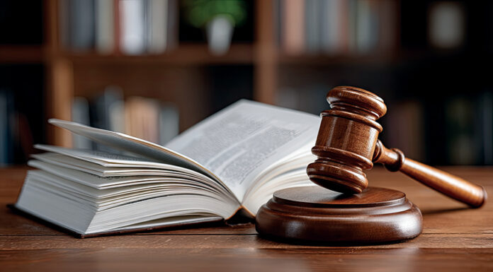 From the bench to the classroom: How judges enhance legal education at Mercer Law A wooden judge’s gavel rests on a sound block next to an open book on a wooden table, with shelves in the background.