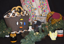 Holiday market to raise funds, visibility for Mercer On Mission Display of handmade crafts including bags, mugs, fabric animals, and greenery with a patterned cloth backdrop.