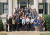 Mercer welcomes 14th class of Stamps Scholars A large group of people in formal attire poses for a group photo on steps outside a building with columns.