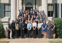 Mercer welcomes 14th class of Stamps Scholars A large group of people in formal attire poses for a group photo on steps outside a building with columns.