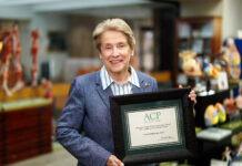 Georgia ACP establishes rural care award in School of Medicine dean’s name Dr. Jean Sumner holds a framed ACP certificate, standing in the MUSM medical library