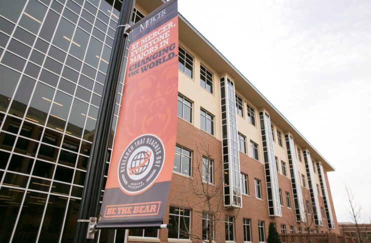 Banner outside the Godsey Science Center reads At Mercer, everyone majors in changing the world.