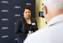 Dr. Loleta Sartin honored for contributions to teacher education A woman is interviewed on camera in front of a Mercer University backdrop, holding a microphone.