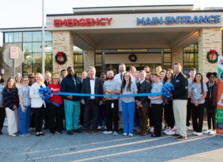 Kids Alliance for Better Care celebrates Colquitt Regional Medical Center’s emergency department as part of the Pediatric Emergency Care Project A group of people stands outside a hospital entrance, holding a large blue ribbon for a ribbon-cutting ceremony.
