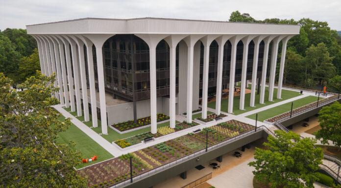 Communication students develop social media strategy for Goodwill A modern, multi-story building with tall white columns and landscaped grounds, surrounded by trees.