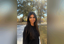 Sophomore chosen for Up to Us Leadership Network civic leaders cohort Woman with long dark hair stands outside on a sunny day, with trees and a walkway in the background.