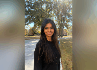 Sophomore chosen for Up to Us Leadership Network civic leaders cohort Woman with long dark hair stands outside on a sunny day, with trees and a walkway in the background.