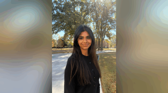 Sophomore chosen for Up to Us Leadership Network civic leaders cohort Woman with long dark hair stands outside on a sunny day, with trees and a walkway in the background.