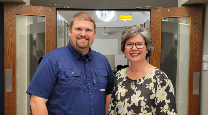 New podcast explores health care challenges, triumphs in rural Georgia Dr. Justin Peterson and Glenda Grant stand smiling inside a building entrance with open wooden doors.
