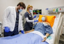 High-tech, real-life simulations prepare Mercer nursing students for practice Two Mercer nursing students practice patient care on a medical mannequin in a hospital room with monitoring equipment.