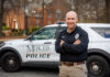 New Mercer Police deputy chief brings skill, expertise and compassion to role Deputy Chief Jeremy Robinson stands with arms crossed in front of a Mercer University Police vehicle parked on a tree-lined street.