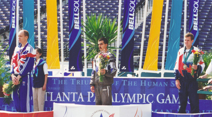 A Paralympic champion, Mercer alumnus uses law degree for disability advocacy Three male athletes stand on a Paralympic podium with medals and flowers at the Atlanta Paralympic Games.