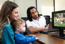 New program expands early autism diagnosis for children in rural Georgia A mother holds her child while he watches a video on the EarliPoint device while the technician oversees.