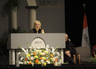 Nancy Grace to deliver 2026 Founders’ Day address A woman in academic regalia speaks at a podium decorated with flowers at a Mercer University event.