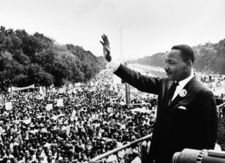Listen to voices that matter most, and shut out noise around you | Dr. Craig McMahan Martin Luther King Jr. waves to a large crowd gathered outdoors during a historic civil rights demonstration.