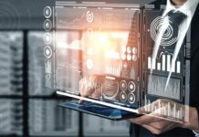 Explore how AI impacts career pathways at Informatics Day 2026 A person in a suit holds a tablet displaying virtual data dashboards, graphs, and analytics interfaces.