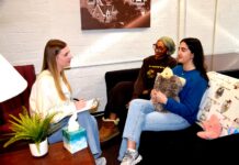 Mercer’s Macon campus launches peer counseling program Three women sit in a cozy room talking; one takes notes, while another holds a stuffed animal on the couch.
