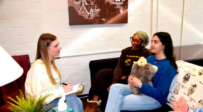 Mercer’s Macon campus launches peer counseling program Three women sit in a cozy room talking; one takes notes, while another holds a stuffed animal on the couch.