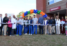 Kids Alliance for Better Care celebrates Wayne Memorial Hospital’s emergency department as part of Pediatric Emergency Care Project A group of people stand in front of an emergency room entrance, holding a ribbon for a ribbon-cutting ceremony.