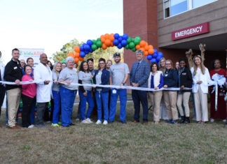 Kids Alliance for Better Care celebrates Wayne Memorial Hospital’s emergency department as part of Pediatric Emergency Care Project A group of people stand in front of an emergency room entrance, holding a ribbon for a ribbon-cutting ceremony.