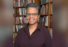 Scholar of African American religious history Judith Weisenfeld to deliver annual Harry Vaughan Smith Lecture A person with short curly hair and glasses smiles while standing in front of a bookshelf filled with books.
