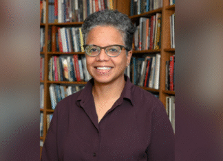 Scholar of African American religious history Judith Weisenfeld to deliver annual Harry Vaughan Smith Lecture A person with short curly hair and glasses smiles while standing in front of a bookshelf filled with books.