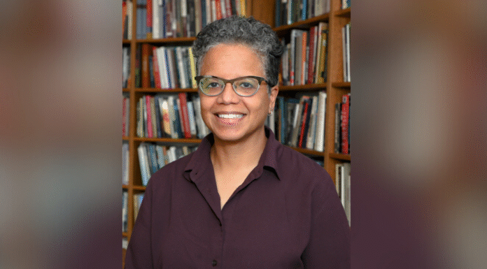 Scholar of African American religious history Judith Weisenfeld to deliver annual Harry Vaughan Smith Lecture A person with short curly hair and glasses smiles while standing in front of a bookshelf filled with books.