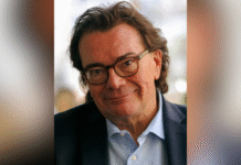 Editor and radio/podcast host Chuck Reece to deliver annual Byington Lecture A middle-aged man with glasses and dark hair, wearing a suit jacket and light blue shirt, smiles at the camera.