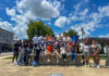 New mentorship program provides international students with extra support A group of people pose together outdoors in front of a large Macon sign on a sunny day.