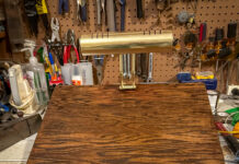 Pick up life’s pieces and mold them into something new | Dr. Craig McMahan A wooden desktop stand with a brass lamp on top, set on a workbench with various tools hanging in the background.