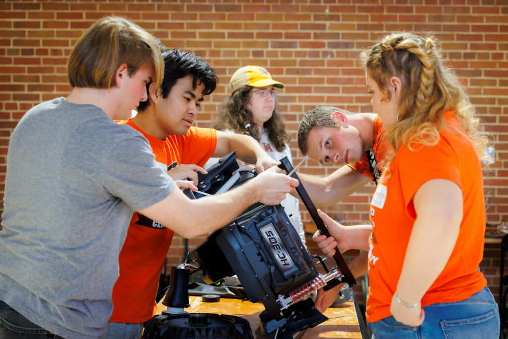 Four Mercer students assemble a toy car.