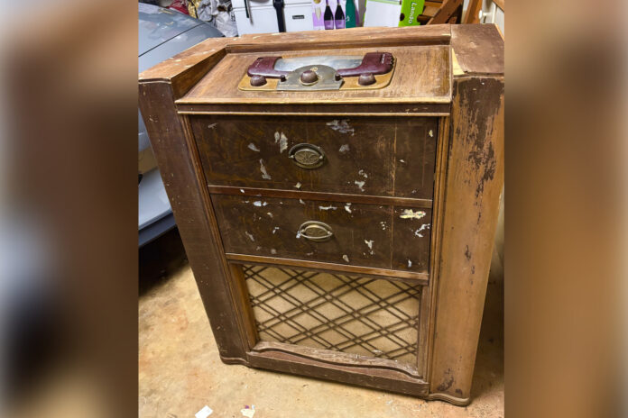 A worn vintage wooden radio cabinet.