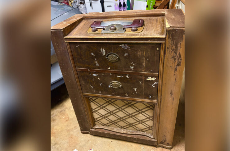 A worn vintage wooden radio cabinet.