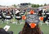Mercer to confer degrees to more than 2,200 graduates at four commencements in May Graduate wearing a decorated cap reading Onto the Next Chapter at an outdoor commencement ceremony with seated attendees.