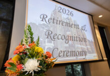 Faculty, staff honored at 2026 Retirement and Recognition Ceremonies A flower arrangement in front of a screen displaying 2026 Retirement & Recognition Ceremony in a conference room.