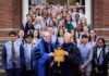 College of Liberal Arts and Sciences inducts 44 students into Phi Beta Kappa Society A group of students and faculty in academic regalia pose on steps, holding a large Phi Beta Kappa key symbol.