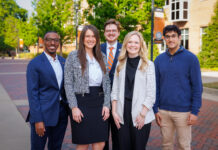 Fellows build leadership, character while working alongside Mercer president Five professionally dressed people stand and smile outside on a brick walkway with trees and buildings in the background.